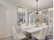 Elegant dining room featuring a white table, white chairs, and patterned wallpaper at 1842 Tropical Palms Cir, Kissimmee, FL 34747