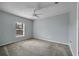 Bright bedroom featuring a window, ceiling fan, and plush carpeting at 526 Maricopa Dr, Kissimmee, FL 34758