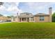 Rear view of house showcasing large grassy yard at 1380 E Lake Shore Blvd, Kissimmee, FL 34744
