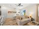 Bright living room with comfy sofas, wood floors, and access to kitchen and dining area at 2980 On The Rocks Pt, Kissimmee, FL 34747