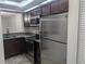 Stainless steel appliances and dark wood cabinets in this galley kitchen at 2912 S Semoran Blvd # 9, Orlando, FL 32822