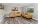 Living room features mustard yellow sofas and wood-look floors at 127 Oyster Bay Cir # 110, Altamonte Springs, FL 32701