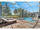 Relaxing pool and spa with screened enclosure and lounge chairs at 1536 Maidstone Ct, Davenport, FL 33896