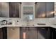 Kitchen sink and dishwasher with dark cabinetry and white quartz countertops at 1536 Maidstone Ct, Davenport, FL 33896