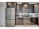 Modern kitchen with dark cabinetry, stainless steel appliances, and white quartz countertops at 1536 Maidstone Ct, Davenport, FL 33896