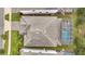 Bird's eye view of a home's roof and pool with screened enclosure at 1536 Maidstone Ct, Davenport, FL 33896