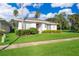 Front view of a single story house with red door and manicured lawn at 2918 Sunset Retreat Ct, Kissimmee, FL 34747