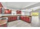 Modern kitchen with dark wood cabinets, granite counters, and stainless steel appliances at 621 Knightsbridge Cir, Davenport, FL 33896