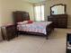 Main bedroom with a large bed, dresser, and nightstand at 1816 Stargazer Trl, Kissimmee, FL 34758