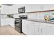 Modern kitchen with white cabinets, gray countertops and stainless steel appliances at 3896 Deer Ridge Dr, Mount Dora, FL 32757