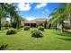 Landscaped backyard with lush lawn and tropical plants at 3757 Eagle Isle Cir, Kissimmee, FL 34746