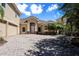 Tan two-story house with paver driveway and landscaping; view from the side at 3757 Eagle Isle Cir, Kissimmee, FL 34746