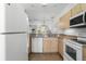 Galley kitchen with white appliances and light wood cabinets at 1256 S Beach Cir, Kissimmee, FL 34746