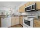 Kitchen with white appliances and light wood cabinets at 1256 S Beach Cir, Kissimmee, FL 34746