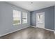 Living room with light grey walls and wood-look floors, and door to outside at 2078 Cypress Bay Blvd, Kissimmee, FL 34743
