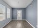 Living room with light grey walls and wood-look floors, and door to outside at 2078 Cypress Bay Blvd, Kissimmee, FL 34743