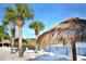 Beachfront lounge chairs and tiki huts offer relaxing lake views at 306 Lucaya Loop # B5/U306, Davenport, FL 33897