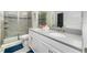 Modern bathroom with double sinks, shower, and gray tile at 1676 Moon Valley Dr, Davenport, FL 33896