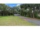 Newly built home nestled amongst mature trees with a gravel driveway at 424 Wilder Rd, Lakeland, FL 33809