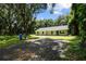 Newly built home nestled amongst mature trees with a gravel driveway at 424 Wilder Rd, Lakeland, FL 33809