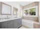 Modern bathroom with double vanity, marble countertop and bathtub at 751 Avenue B Sw, Winter Haven, FL 33880