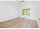 Spacious bedroom with ceiling fan, large window, and light flooring at 751 Avenue B Sw, Winter Haven, FL 33880