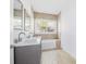 Modern bathroom with double vanity, marble countertop and bathtub at 751 Avenue B Sw, Winter Haven, FL 33880