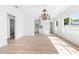 Dining room with chandelier, hardwood floors, and view of kitchen at 751 Avenue B Sw, Winter Haven, FL 33880