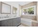 Modern bathroom with double vanity, marble countertop and bathtub at 751 Avenue B Sw, Winter Haven, FL 33880