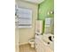 Clean bathroom with white vanity and a green accent wall at 6265 Contessa Dr # 101, Orlando, FL 32829