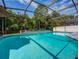Inviting screened pool with a waterfall feature and lush landscaping at 1049 Lake Berkley Dr, Kissimmee, FL 34746