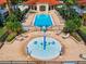 Community pool and splash pad with surrounding lounge chairs and landscaping at 1049 Lake Berkley Dr, Kissimmee, FL 34746