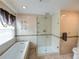 Bathroom with soaking tub, walk-in shower, and updated fixtures at 1049 Lake Berkley Dr, Kissimmee, FL 34746