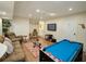Finished basement with pool table, seating area, and large TV at 1049 Lake Berkley Dr, Kissimmee, FL 34746
