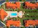 Aerial view of community pool and surrounding buildings and parking areas at 1049 Lake Berkley Dr, Kissimmee, FL 34746