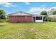 Brick house with screened porch and well-maintained lawn at 7819 Puritan Rd, Orlando, FL 32807