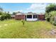Brick home exterior, spacious lawn, and screened porch at 7819 Puritan Rd, Orlando, FL 32807
