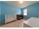 bedroom with crib, dresser, and light blue walls at 794 Citrus Isle Dr, Davenport, FL 33837