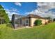 Rear view of house with screened patio and green lawn at 341 Navarra Ln, Davenport, FL 33837