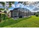 Backyard view of the screened patio and grassy area at 341 Navarra Ln, Davenport, FL 33837