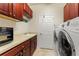 Bright laundry room with washer, dryer, and wooden cabinets at 341 Navarra Ln, Davenport, FL 33837
