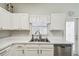 White kitchen features double sink, dishwasher, and ample cabinetry at 123 Gulf Dr, Kissimmee, FL 34759