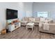 Large living room with L-shaped sectional sofa and wood-look floors at 872 Sydney St, Davenport, FL 33837