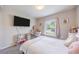Bedroom with a modern vanity, wall-mounted TV and pink accents at 872 Sydney St, Davenport, FL 33837