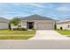 One-story home with gray siding, gray garage door, and landscaping at 872 Sydney St, Davenport, FL 33837