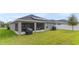 Backyard view showcasing a covered patio with a grill and lush green lawn at 872 Sydney St, Davenport, FL 33837