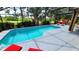 Inviting screened pool with red lounge chairs at 1652 Dunes Ct, Haines City, FL 33844