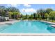 Community pool with lounge chairs and surrounding landscaping at 4523 Cypress Cay Way, Kissimmee, FL 34746