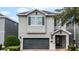 Two-story house with gray siding, dark green garage door, and landscaping at 7617 Brookhurst Ln, Kissimmee, FL 34747