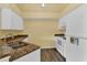Kitchen features granite countertops and white appliances at 4611 Gate Pl # H-203, Orlando, FL 32811